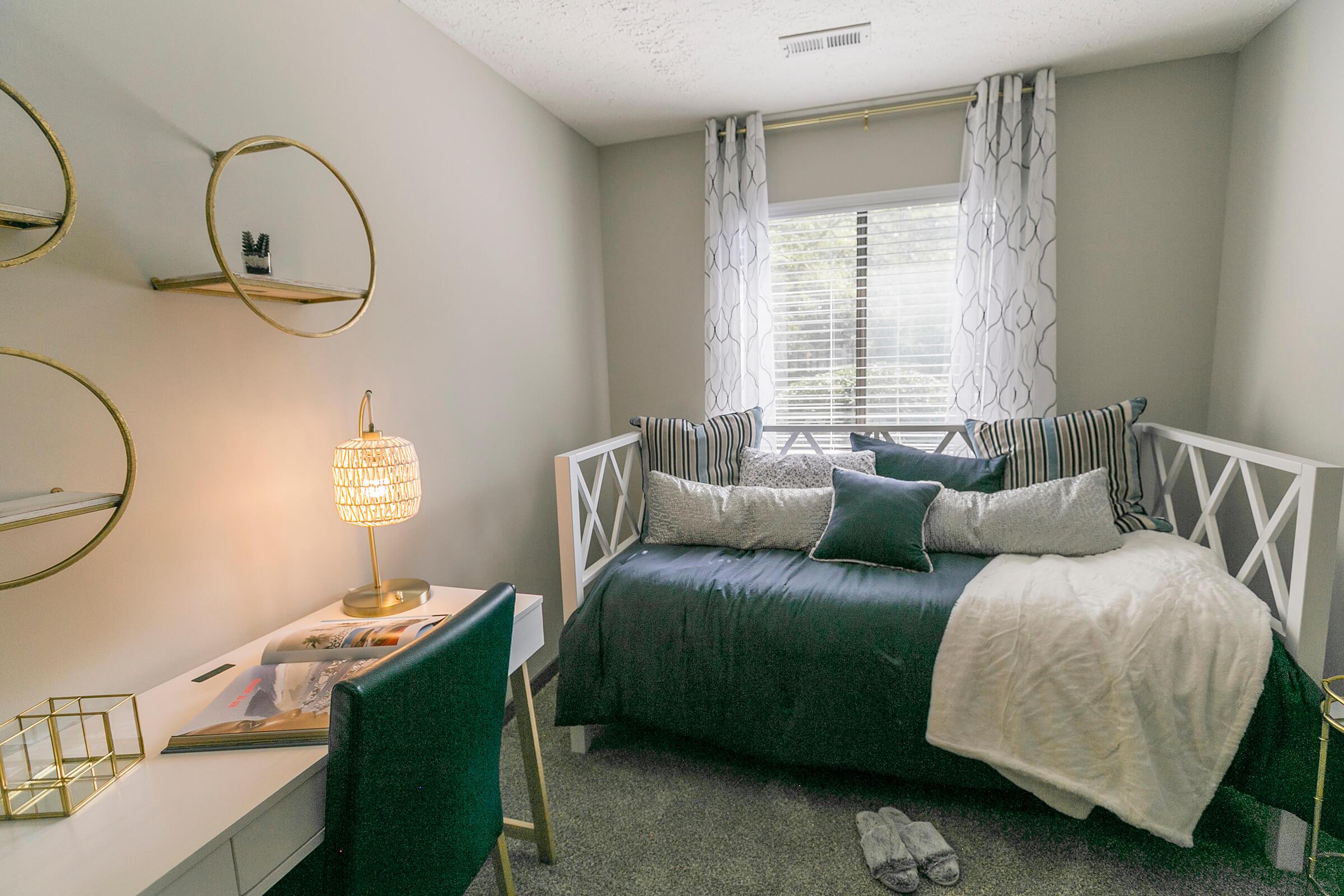 Green daybed and room with desk.